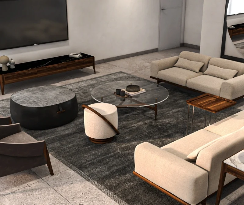 Contemporary living area interior design with a sectional cream sofa and matching armchairs centered around a glass coffee table. The space is adorned with a large area rug and features a minimalist media unit with a large TV against a textured wall.